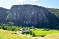 Den karakteristiske 300 meter høge loddrette fjellveggen er ein del av fjellet Ånås. Garden er Vestre Fjågesund (gnr. 20/11). Foto: Roy Olsen (2025).