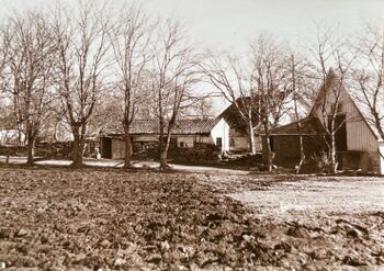 Østbø br. 7.1 - Redskapshus og baksiden av fjøs. Gårdshuset i bakgrunnen.