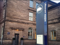 Lillestrøm stasjon med minneplaketten på veggen til venstre for stasjonsskiltet. Foto Lisbeth Lund Andresen, Romerikes Blad.]]