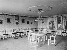 Festsalen, sett mot det sørøstre hjørnet. Vinduet vender ut mot hagen i sør. Foto: Anders Beer Wilse/Norsk Folkemuseum (1919).