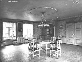 Festsalen, sett mot det sørvestre hjørnet. Vinduene vender ut mot hagen i sør. Foto: Anders Beer Wilse/Norsk Folkemuseum (1919).