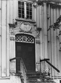 En av inngangsdørene mot sjøen, de små knekkede ornamentene i de øvre hjørnene er typisk for kristiansundsarkitekturen. Foto: Anders Beer Wilse/Norsk Folkemuseum (1919).