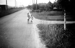 Fetveien i krysset med Slettheimveien, tatt 1950, mot vest. Barna på bildet er Gerd og Vidar Lurud, på vei fra Granaveien, (hvor de bodde i det som da het Hus nr 52) til sitt nye hus som var under oppførelse i Slettheimveien. Fotokilde Vidar Lurud.