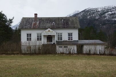 Mardal skule. Kvitt hus med ei karakteristisk tak eller vindfang over hovuddøra, med eit relief og teksten "1884 * Mardal skule * 1924". Huset har ein kjellaretasje delvis over bakkeplan, og ei stor trapp opp til hovuddøra i ein høg førsteetasje.
