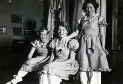 Mia og to medpasienter i knekorte bomullskjoler med rysjer og pynt, pluss mamelukker. Kjolene var laget til et karneval på Granheim lungesanatorium. Mia i et tenksomt øyeblikk, til venstre. Foto: Ukjent