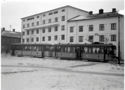 Motorvogn og tilhenger, første boggivogn i sløyfen rundt Voldsminde, med nye boligblokker. 1938. Fotograf Schrøder/Sverresborg - Trøndelag Folkemuseum
