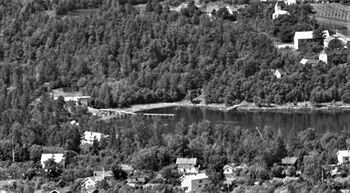 Bilde fra 1958 viser «Den store isbrygga» og den bakenforliggende isstabelen. Vi ser også «Den lille isbrygga» i vannkanten til høyre for stranda. (Foto: Widerøe/Nasjonalbiblioteket)