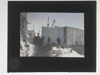 NPRA179. Vingene bæres fra kaia til den såkalte monteringsplassen i Ny-Ålesund. Foto: Nasjonalbiblioteket