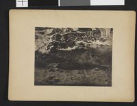 Inuittbolig av jord og stein, i forgrunnen en nyfanget sel.