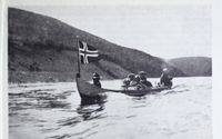 Elvebåt på Tana - med påhengsmotor og norsk flagg. Foto: Det Norske næringsliv. 13 : Finnmark fylkesleksikon, s. 95 (1952).