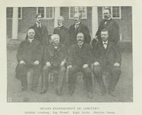 Hvams byggekomité og arkitekt. Arkitekt Arnstein Arneberg, ingeniør Wessel, kaptein Laake, bestyrer Døsen, kirkesanger Opsand, amtmann Furu, disponent Strøm og gårdbruker Lunner. Illustrasjon fra boka "Akershus amt 1814-1914" av A. Th. Kiær, 1921.