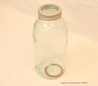 Et glass som rommer 2 liter. Dette er en gammel type med smal hals og har en gummiring som følger for å tette lokk og glass slik at det ble lufttett. Det ble benyttet til å konservere og bevare mat og drikke over lengre tid. Foto: Røyken Historielag/Jan Smieseth