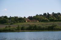 Østensjø gård, som har gitt navn til bydelen. I forgrunnen sees Østensjøvannet. Foto: Kjetil Ree (2008).