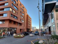 Parti fra Operagata, sett vestover fra området ved gatetunet/lekeplassen ved hjørnet med Munch brygge til venstre, Den norske opera & ballett bak, midt i bildet. Foto: Pål Giørtz (2022).