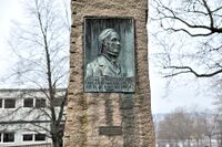 Bauta med portrettrelieff av Hans Nielsen Hauge ved Bredtvet kirke utført av Erling Grønland. Foto: Roy Olsen (2014).