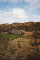 Gammalt tømmerhus ovom Besselvågen ved Sørvågen i 1994. I dag (2008) er huset borte. Vi skimtar bygningane til Glåpen fyr attom bergryggen i bakgrunnen.