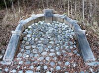 Original steinportal fra Bærum sykehus, demontert i 1964, senere plassert i skåring ved Gyssestad gård som dekorasjon. Foto: Stig Rune Pedersen (2023)