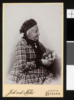 137. Portrett av en eldre, uidentifisert kvinne med blomsterbukett - no-nb digifoto 20160317 00418 blds 05787.jpg