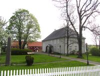 Prestegården ved Vestby kirke, med bautaen over Johan Herman Wessel i forgrunnen til venstre. Foto: Stig Rune Pedersen