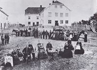 Rogneby i 1867. Bildet demonstrerer de enorme klasseskillene på storgardene, med sjølfolka foran og tjenestefolka bak.