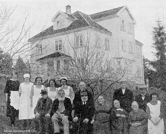 Det første sykehjemmet i Røyken som sto ferdig i 1910, brant ned julaften 1916. Nytt bygg sto ferdig på samme sted (Grette) våren 1919. Her er beboere og betjening foran det nybygde sykehjemmet.(Fotograf ukjent / Røyken Historielags billedsamling)