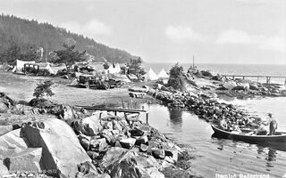 Allerede fra slutten av 1920-årene fikk reisende lov å slå opp telt der. Fra 1931 startet Hans Ramton landets andre campingplass. Bildet viser campinglivet slik det fortonet seg på begynnelsen av 1930-tallet. Foto: Harstad forlag