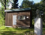 Ada Madssens byste av forfatteren Kåre Holt foran dikterstua hans, som ble flyttet til Reidvintunet i 1997. Foto: Stig Rune Pedersen