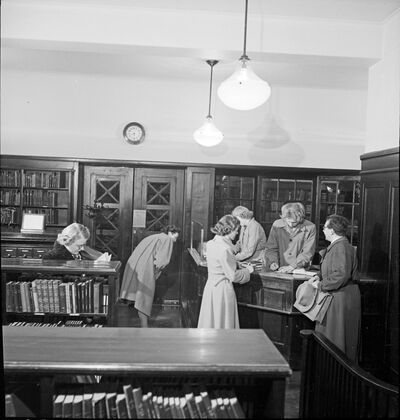 Fra utlånsavdelingen, ca 1950. Senere biblioteksjef Arne Kr. Sollid bemanner skranken. Foto: Alfred Holtan, Tinn kommune
