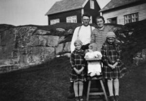 Ole og Margit Rognsvåg med døtrene (frå venstre) Bergith, Marie og Elen. Huset deira bak til høgre. Til venstre Kristoffer Rognsvåg (bnr 3-3) sitt hus, det vart flytta til Austrheim.