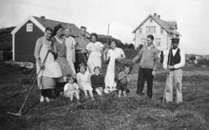 Frå slåtten i Grenda om lag 1935, huset til høgre, Gullak (15) sitt hus til venstre. Bak frå venstre: Monsina (16), Bertha (17), Signy (16aa), Gerhard (16f), Thora (16f), Solveig (16d), Einar Ingvaldsen (Muren bnr 80-1a), Johan (16). Framme frå venstre: Solveig (17c), Bergliot (17a), Othelia Ophaug (Kopper bnr 294-1e), Bjarne (son til 16d).