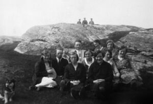 Bak frå venstre: Gunhild Herøy, Alfred Andersen, ukjend (bakom), Sigvald Stormark m/trekkspel, Elisabeth Nordby, Solveig Herøy, Jenny Stormark (framom), Ruth Fredheim. Framme frå venstre: Olga Herøy, Anna Josefina Stormark (bakom), Emma Stormark. Om lag 1934 på Storhaugen, ein møteplass for ungdomane på Stormark.