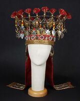 Denne brudekronen har innskrift fra 1815. Den kommer fra gården Helland i Ullensvang der Magdalene Margrethe Koren (1767-1842) leide ut brudeutstyr. Johan Koren Lund (1833-1892) arvet senere kronen og barnebarnet Marit Sendstad solgte den til museet i 1956.