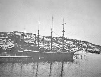 LASTER IS VED DEN LANGE ISBRYGGA 1880-1900.Seilskute liggende for lasting av is ved den lange isbrygga ved Bryggebakken. Brygga på Mellomstranda i forgrunnen. I bakgrunnen ligger en skute ved den lille isbrygga ved Bryggebakken. (Foto fra Nærsnesalbumet)