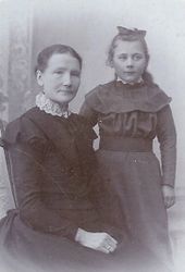 Serine Jacobsen, i 1901, 54 år, Stavanger, sammen med sitt barnebarn, Marie, 9 år. Tæringen er synlig i Serines ansikt. Foto: Ukjent