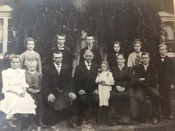 Familien på Nordre Skott i 1906. Bak fra høyre: Torstein, Marta, Lukris, Jens, Guttorm, Stina. Foran fra venstre: Ida, Ragnvald, Atle, Torgeir (far), Valborg, Eli (mor), Sivert