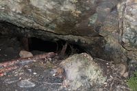 Inne i gruva. Gangen videre inn, som er for trang og farlig til å begi seg inn i, er støtta opp av tømmerstokker. Foto: Chris Nyborg (2014).