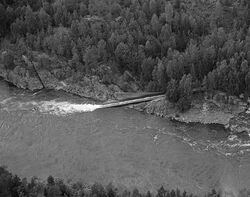 Utløpet av tmmerrenna forbi fossen. Foto: Ole-Thorstein Ljøstad/Anno Norsk Skogmuseum (1985).