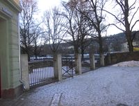 Plassen på vinterstid. Porten i gjerdet leder inn i Minneparken. Foto: Stig Rune Pedersen (2013)