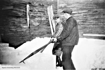 Stabling av isblokker fra Høvikdammen i isstabelen. Etterpå ble det isolert med sagflis. Tatt ut og solgt utover våren/sommeren.T.h. er Fredrik Høvik. Den andre ukjent. (Fotograf ukjent) .
