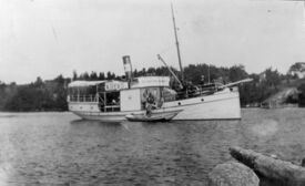 Fartøyet plukket opp passasjer som kommer ut med robåt. Foto: Eiker Arkiv (1920).