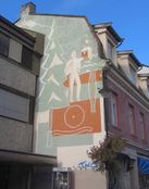 Storgata 11: Veggmaleri med Kongsberg-motiv, utformet av Rolf Hansen og Øyvind Hansen, malejobben utført av Gunnar Mosebekk. Foto: Stig Rune Pedersen