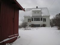 Strandsitterhuset med hovedhuset i bakgrunnen. Foto: Henning Sæther. (januar 2008.).