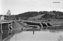 Tømmervelte ved Kjellerholen gård. Bru fra 1939 til venstre, rester av tømmerpeler etter bru fra 1877 til høyre.
