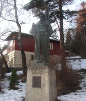 Statue av Thorleif Haug i Drammen , nær innkjøringen til Spiralen, utført av Per Palle Storm, avduket av kronprins Olav i 1946.