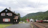 Tinnoset stasjon på Tinnosbanen med jernbanefergen MF «Storegut» ved kai i bakgrunnen. (1909). Foto: SRS scandiline (2004).