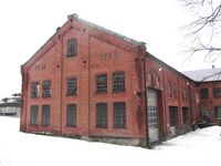Tresliperiet Mago B tilhørende Eidsvoll verk, ved Ludvigsfossen. Mago B ble bygd 1894 og var i drift til 1940. Initialene H.M. på veggen står for Haaken Mathiesen. Foto: Stig Rune Pedersen (2012).