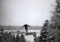 I Vardebakken hadde hopperen direkte utsikt ned mot Asak skole på sletta i bakgrunnen. I svevet: Rolf Kaalstad.