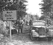 Vegskilt med tysk tekst under krigen.