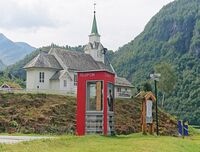 Ved kyrkja ligg ein av dei 100 verna telefonkioskane i landet. Foto: Knut Kjørkleiv (2024)