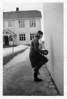 I bakgrunnen: Skolebygningen på Vindingstad ca. 1953. Reidunn kaster ball. Veggen på utbygget på lærerboligen var den beste ballveggen. Panel av pløygde bord - jevn og fin.